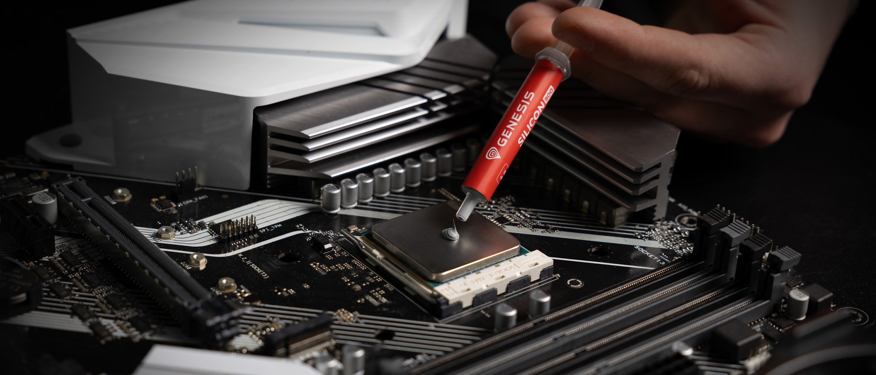 Auftragen von Genesis Silicon 900 Wärmeleitpaste auf einen CPU-Sockel auf einem Motherboard zur Verbesserung der Wärmeleitfähigkeit