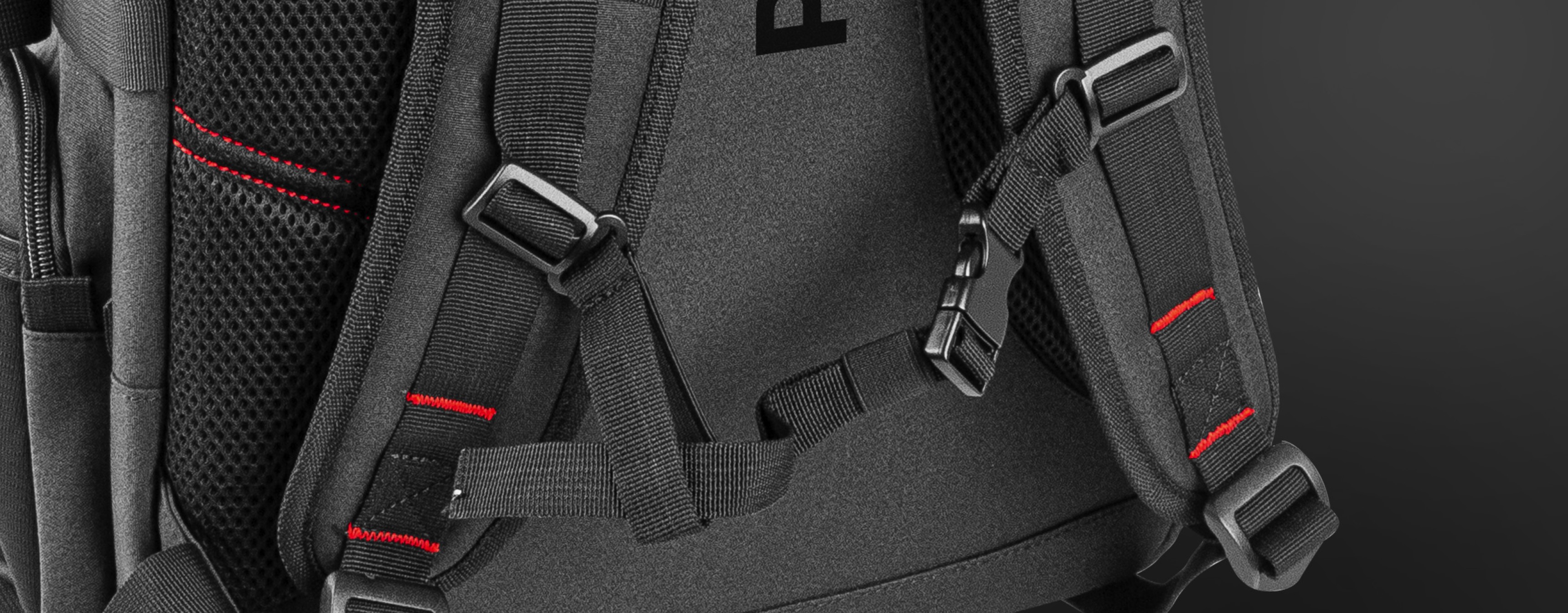 Nahaufnahme des Genesis Pallad 550 Laptop-Rucksacks mit verstellbaren Trägern und reflektierenden Details auf einer schwarzen Oberfläche
