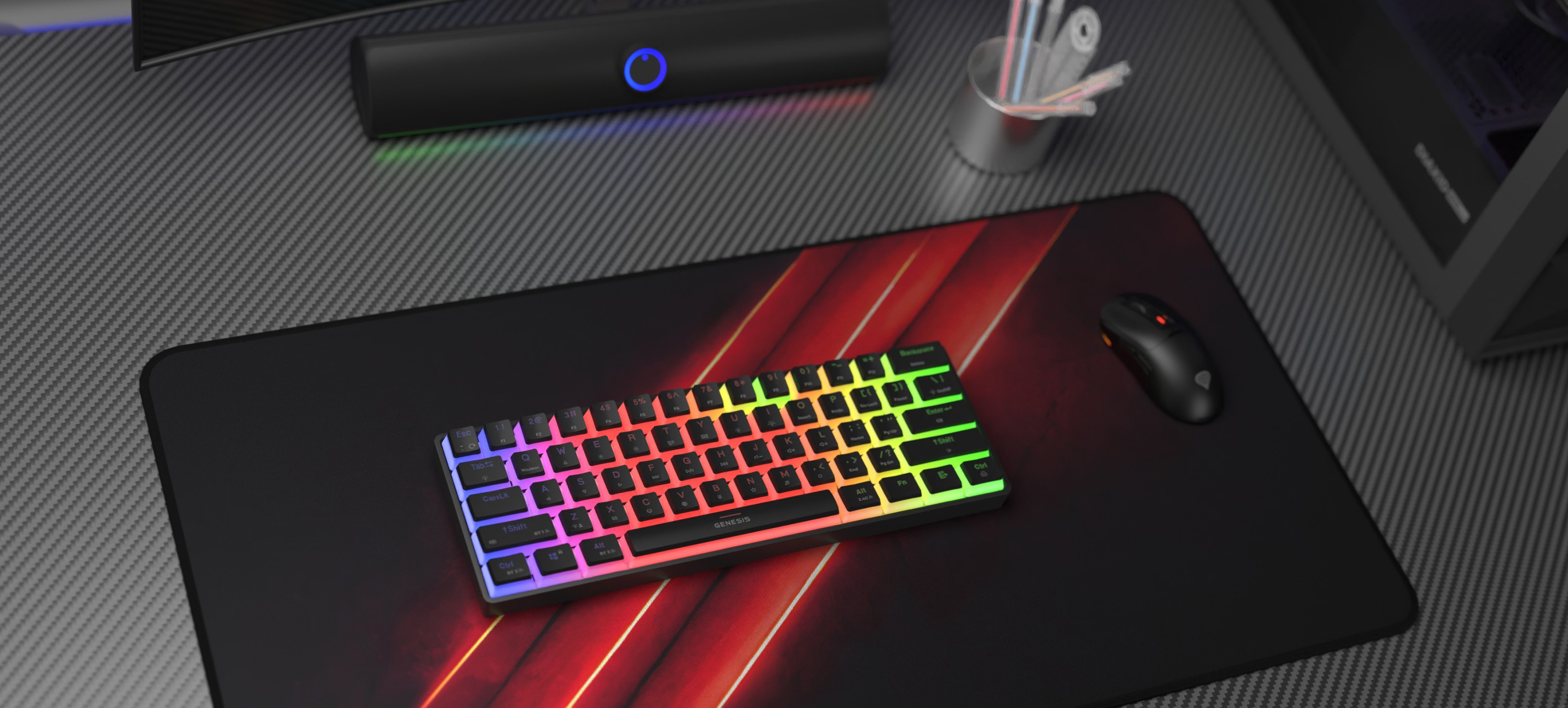 Kabellose mechanische Gaming-Tastatur mit RGB-Beleuchtung, platziert auf einem schwarzen Gaming-Mauspad zusammen mit einer Gaming-Maus und Schreibtischzubehör
