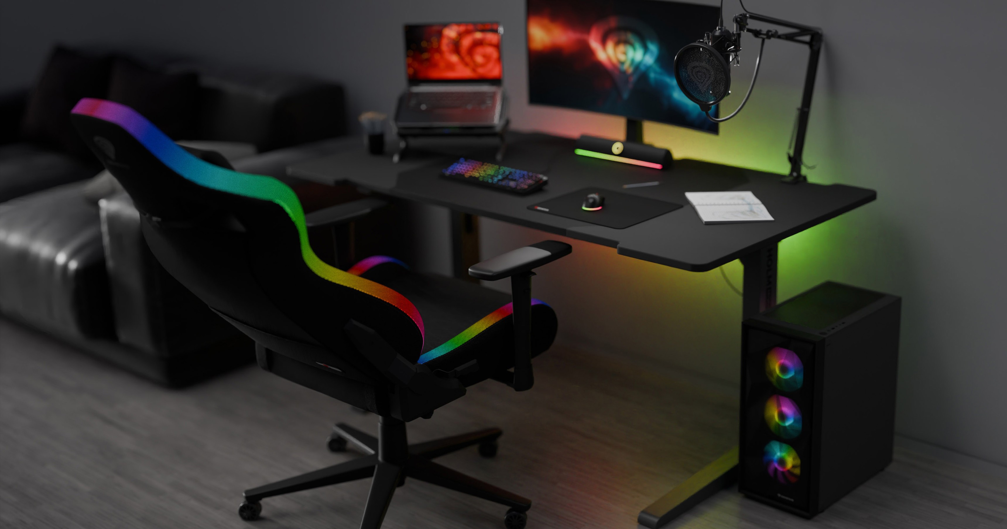 Ein schwarzer Gaming-Stuhl mit RGB-Akzenten steht neben einem eleganten Schreibtisch mit Monitor, Tastatur und buntem Gaming-Setup